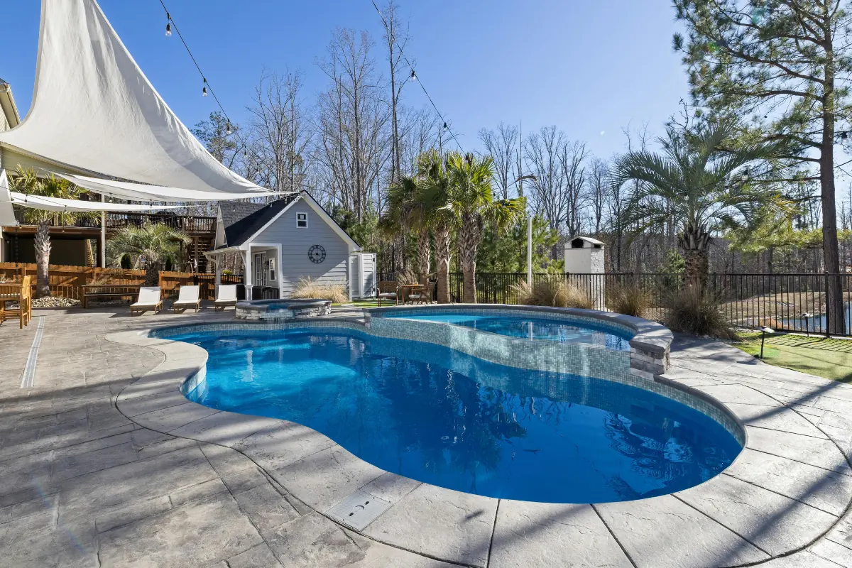 Stamped concrete pool deck wrapping a freeform pool in the Western NC mountains - The Western NC Concrete Company
